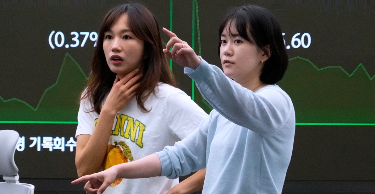 موظفتان تطالعان شاشات التداول في سوق العملات في سيول