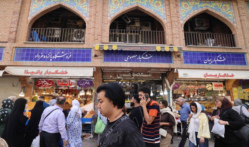 إيرانيون أمام متاجر في البازار الكبير وسط طهران (أ.ف.ب)