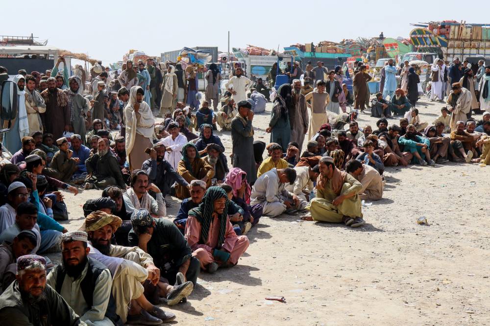  
مواطنون أفغان ينتظرون العودة إلى بلادهم بعد أن أغلقت باكستان المعابر الحدودية (رويترز) 
