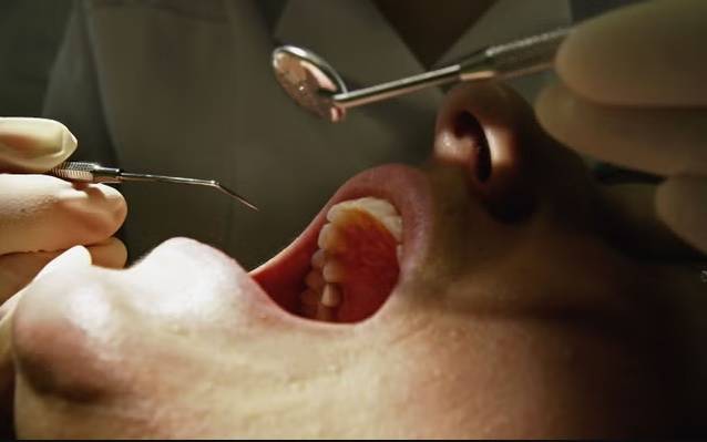 طبيب أسنان يعاين مريضاً