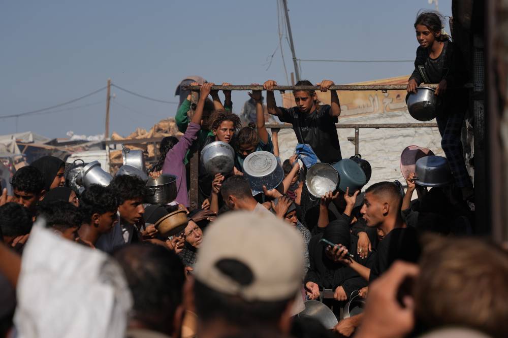 فلسطينيون ينتظرون الحصول على مساعدات في خان يونس (أ ب)