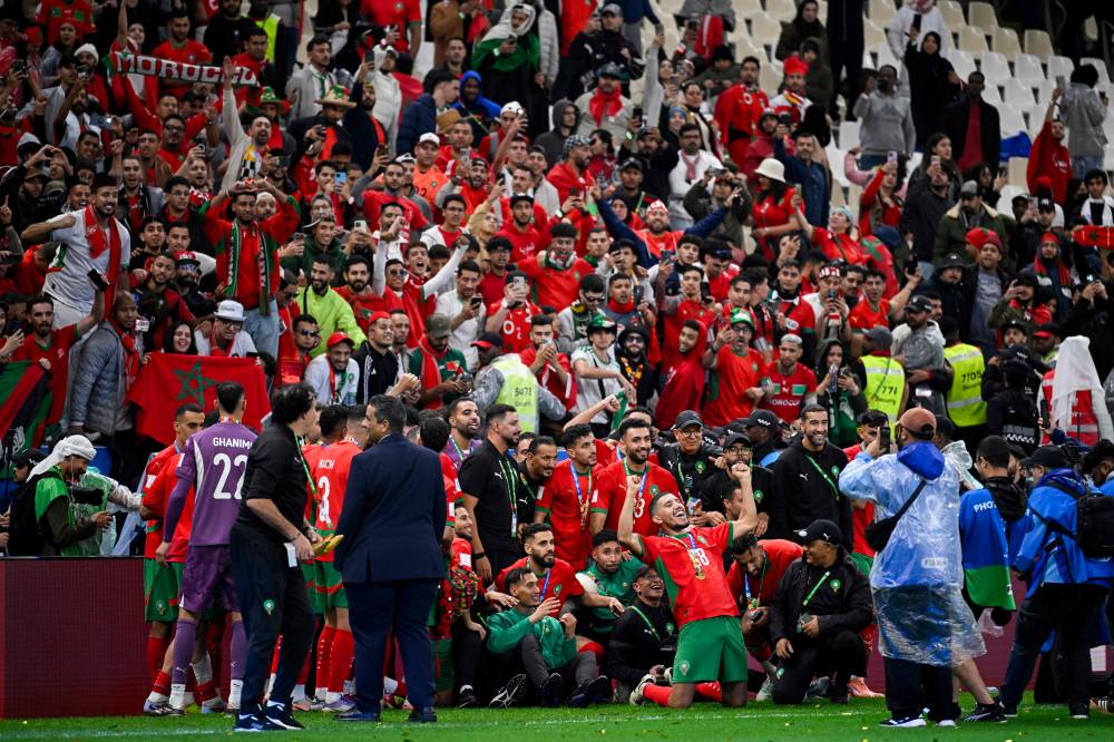 Morcco's players celebrate with the fans after winning the FIFA Arab Cup 2025 final football match between Jordan and Morocco at the Lusail Stadium Stadium, in Lusail on December 18, 2025. (Photo by Mahmud HAMS / AFP)