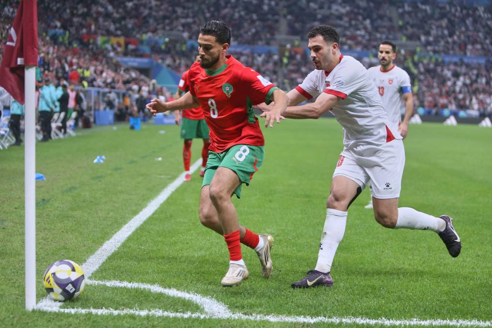 Morocco's Sabir Bougrine, left, vies for the ball with Jordan's Mohannad Abutaha during to the FIFA Arab Cup final soccer match between Jordan and Morocco in Lusail, Qatar, Thursday, Dec. 18, 2025. (AP Photo/Hussein Sayed)