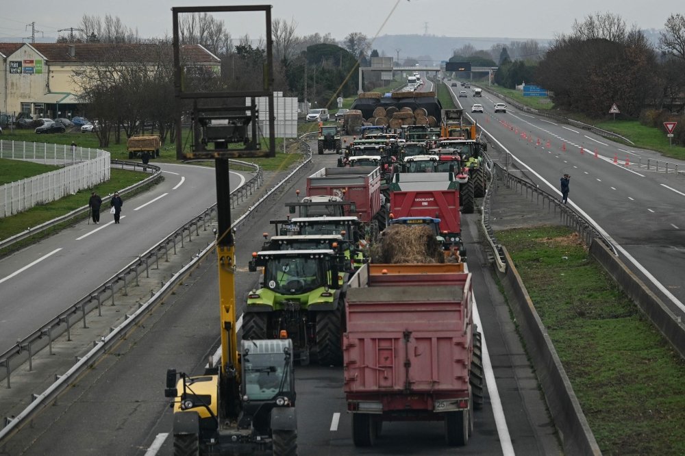 جرارات على طول الطريق السريع A64 خلال اعتصام للمزارعين الفرنسيين في كاربون جنوب غرب فرنسا (أ.ف.ب)