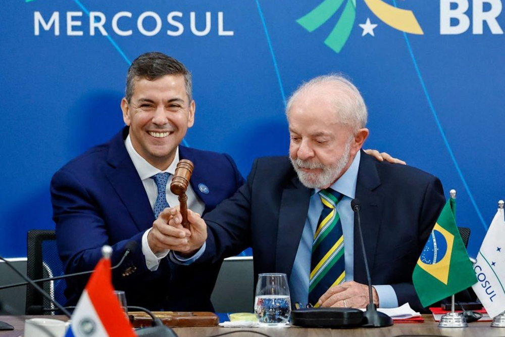  لولا دا سيلفا رئيس باراغواي سانتياغو بينا يحملان مطرقةً خلال قمة رؤساء دول ميركوسور في البرازيل (أ.ف.ب)