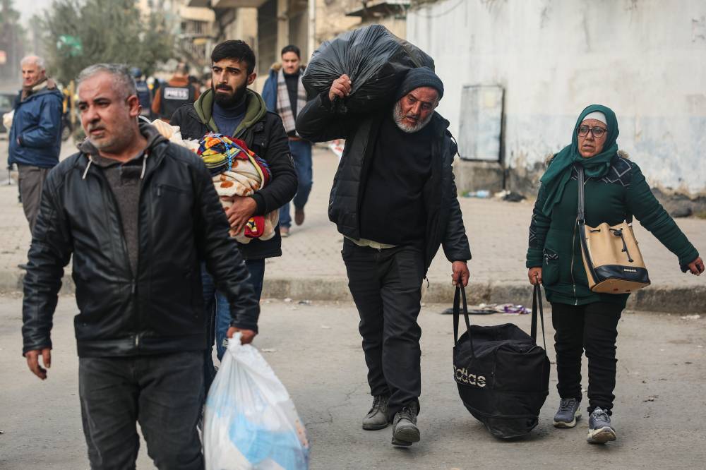 سكان يفرون من حيّي الشيخ مقصود والأشرفية الواقعين شرقي حلب (أ ب)