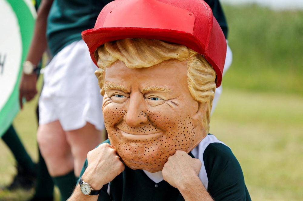 ناشط يرتدي قناعا يشبه ترامب خلال احتجاج لأوكسفام أمام اجتماع مجموعة العشرين، في جوهانسبرج (أرشيفية)