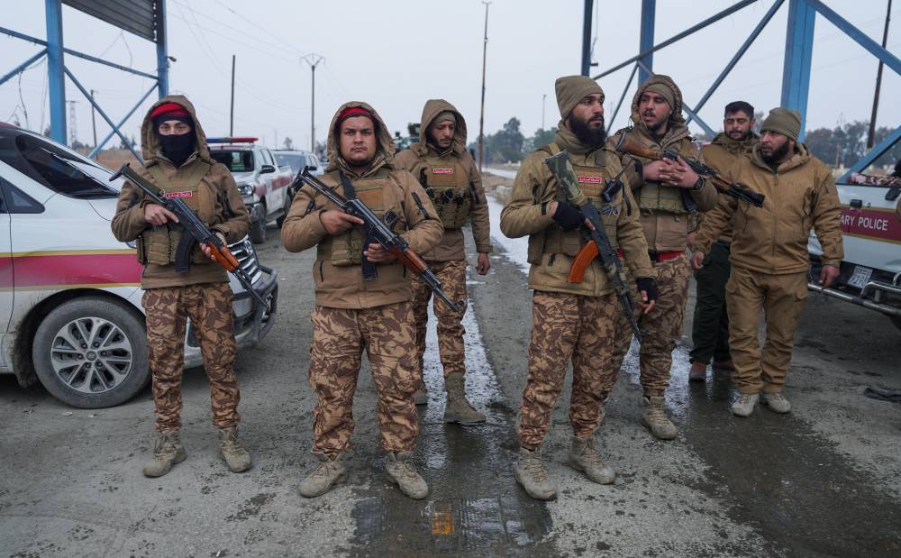 أفراد من الشرطة العسكرية السورية خارج سجن الأقطان في الرقة (رويترز)