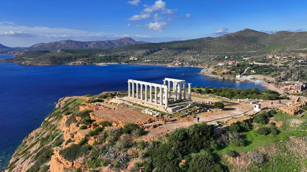 Aerial drone photo of iconic archaeological site of Cape Sounio and famous Temple of Poseidon built uphill overlooking Aegean sea, Attica, Greece