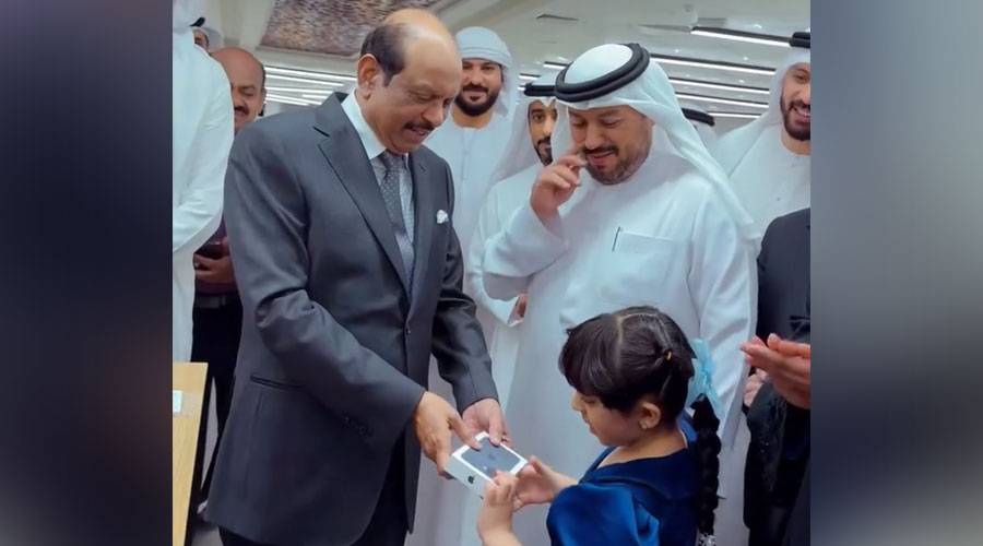 يوسف علي يهدي طفلة جهاز «آيفون 17» خلال افتتاح «لولو» في كلباء