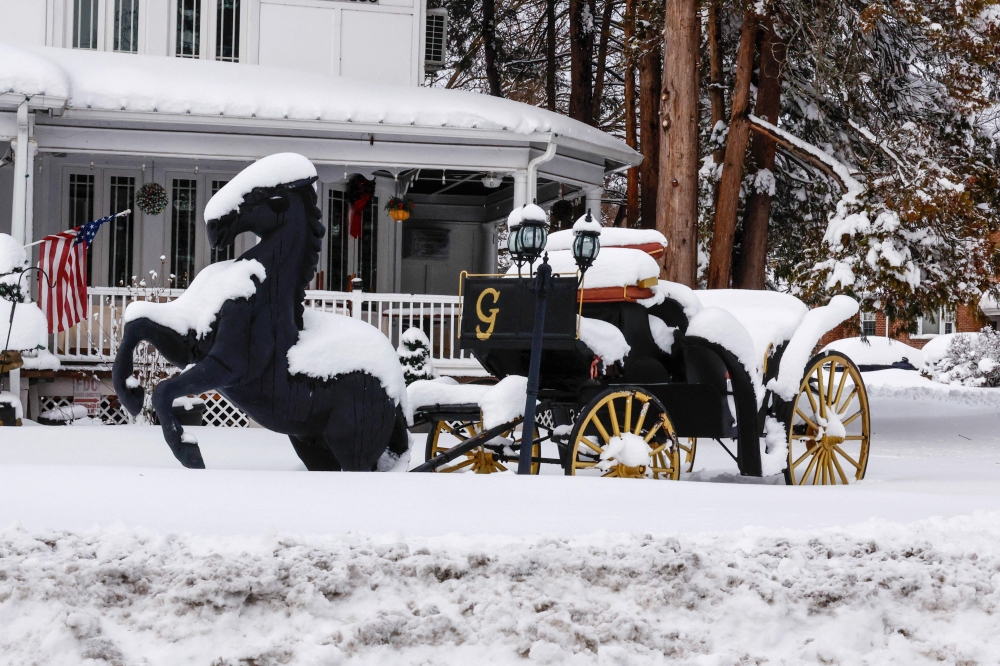  تمثال لحصان يجر عربة مغطى بالثلوج خلال عاصفة في تابان، نيويورك (غيتي)
