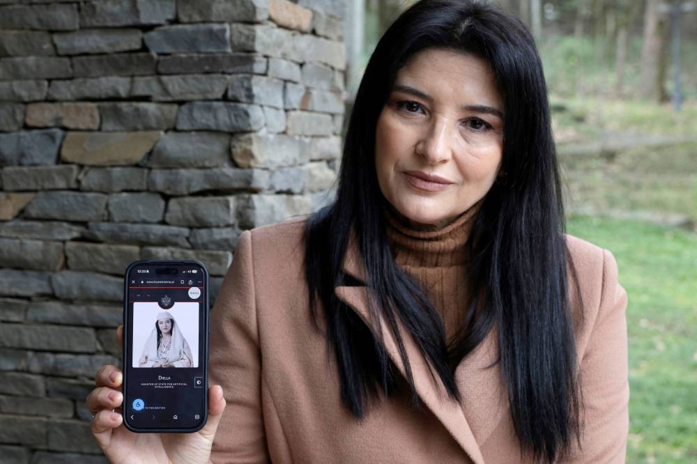 أنيلا بيشا تعرض صورة الوزيرة الافتراضية على هاتفها (أ.ف.ب)