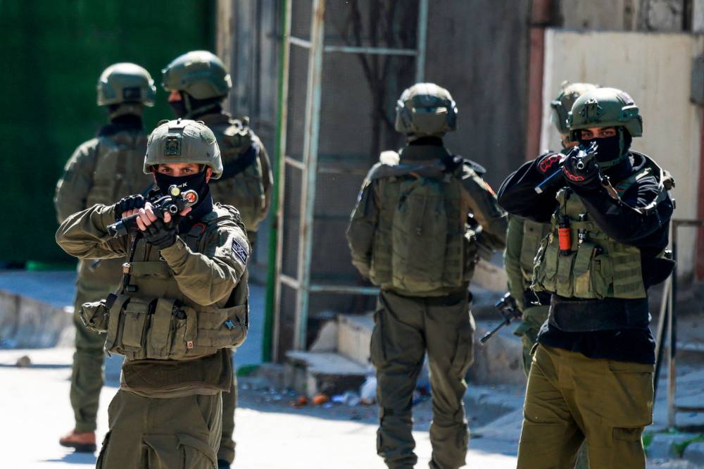   جنود الاحتلال يصوبون أسلحتهم تجاه الفلسطينيين خلال اقتحام مخيم عسكر 
(ا ف ب) 