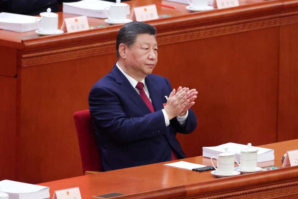 الزعيم الصيني شي جين بينغ يصفق خلال الجلسة الافتتاحية للمجلس الوطني لنواب الشعب في بكين (رويترز)