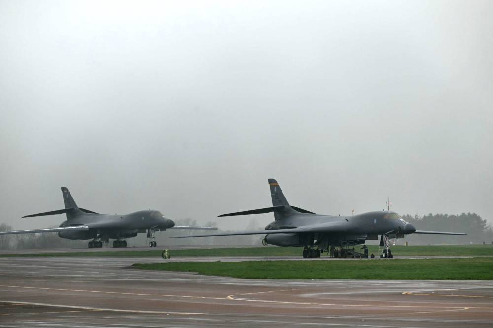 عسكريون يقومون بصيانة قاذفة قنابل أمريكية في قاعدة بجنوب غرب إنجلترا (أ ف ب)