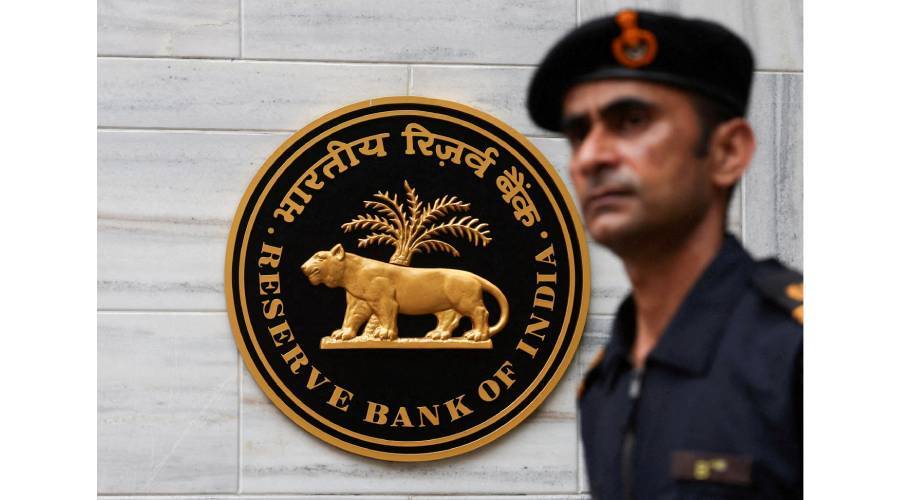 رجل أمن يمر أمام شعار البنك المركزي الهندي  خارج مقره في مومباي (رويترز)