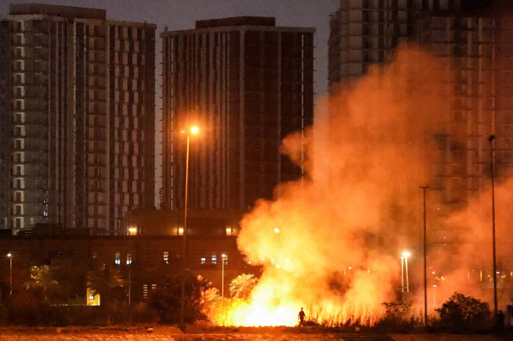 ألسنة اللهب تتصاعد في حرم مقر السفارة الأمريكية في بغداد بعد هجوم صاروخي بمسيرة (أ ف ب )