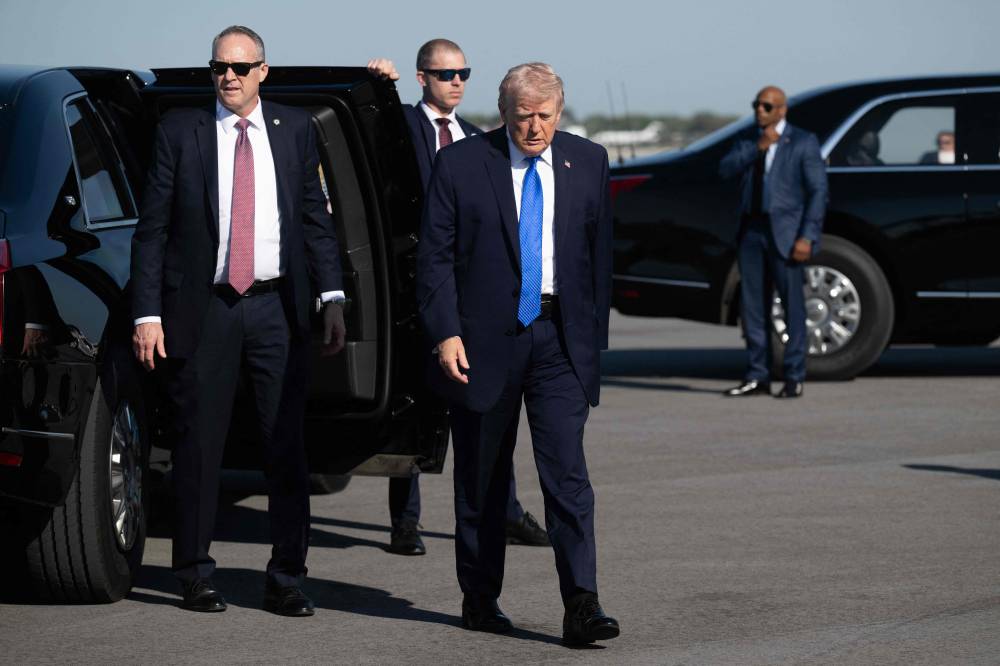 ترامب يتوجه إلى الصحفيين للتحدث معهم قبل صعوده على متن طائرة الرئاسة في فلوريدا(أ ف ب)