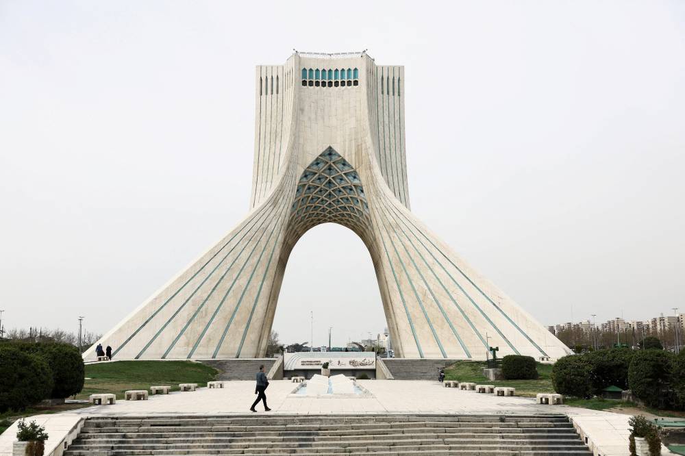 A man walks past Azadi Square, amid the U.S.-Israeli conflict with Iran in Tehran, Iran, March 23, 2026. Majid Asgaripour/WANA (West Asia News Agency) via REUTERS ATTENTION EDITORS - THIS PICTURE WAS PROVIDED BY A THIRD PARTY TPX IMAGES OF THE DAY