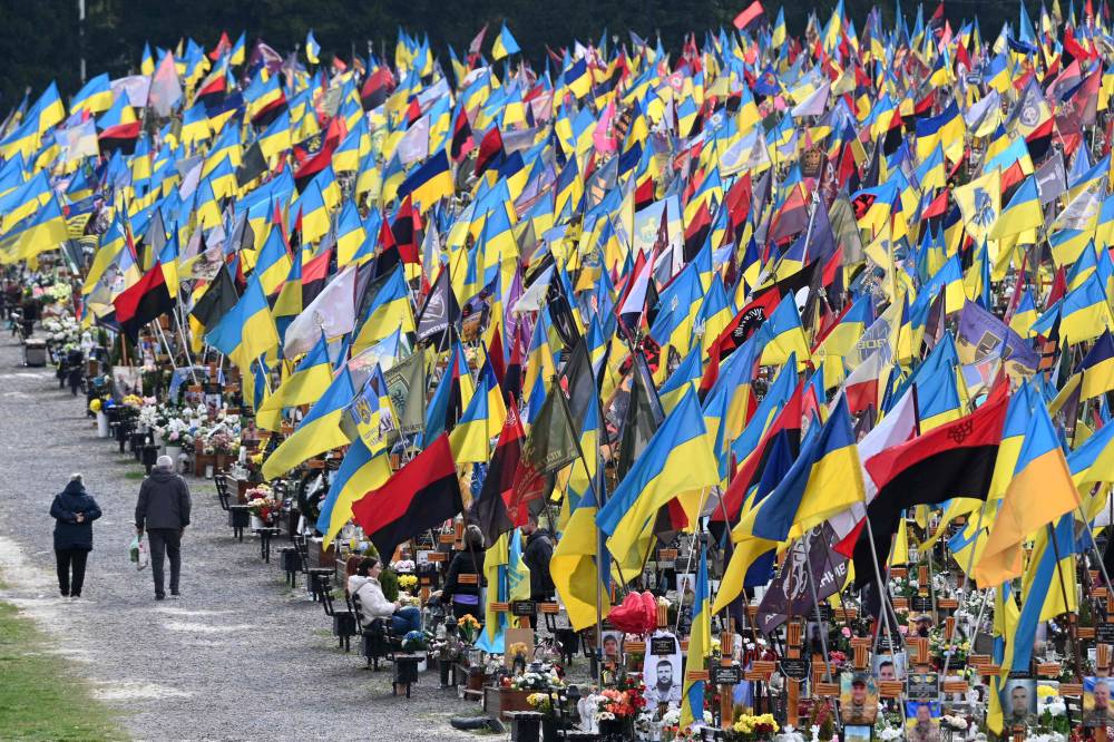  أوكرانيون يزورون مقبرة لايخيف العسكرية بمناسبة عيد الفصح (أ.ف.ب)